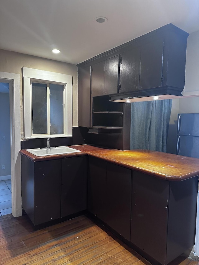 kitchen with dark wood-type flooring, sink, and kitchen peninsula