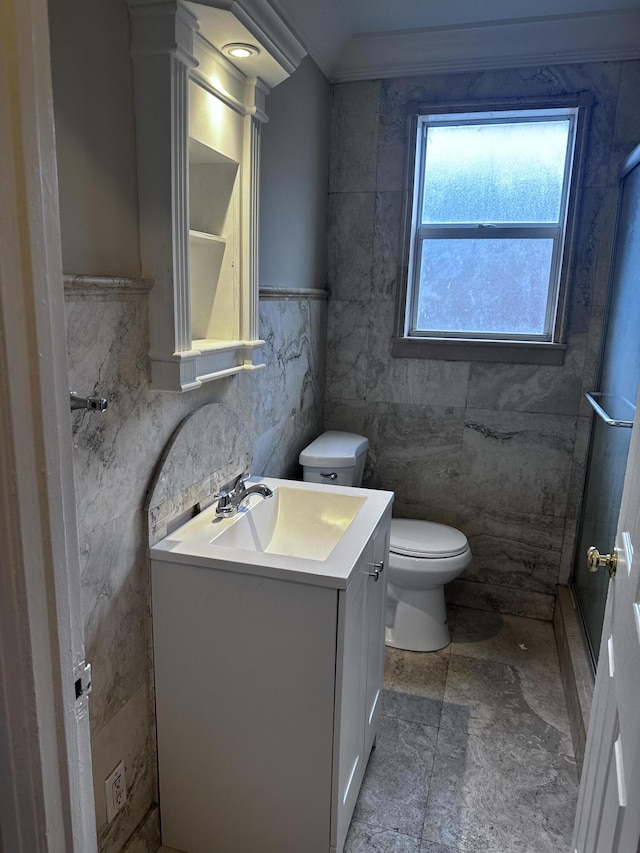 bathroom with toilet, tile walls, walk in shower, vanity, and crown molding