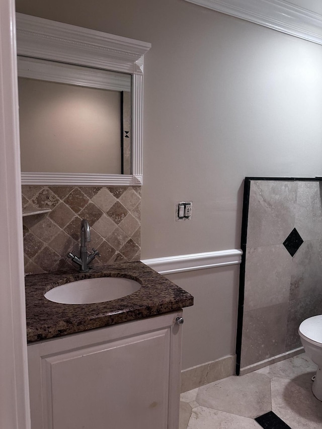 bathroom with toilet, tile walls, vanity, crown molding, and tile patterned flooring