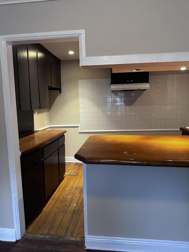 kitchen with dark wood-type flooring and decorative backsplash