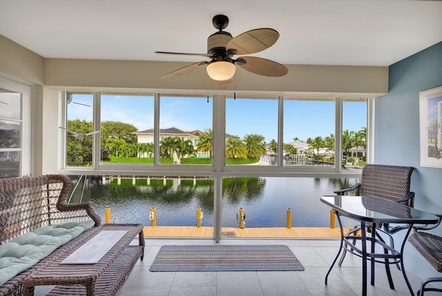 sunroom / solarium with ceiling fan and a water view