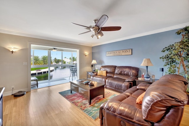 living room featuring light wood-type flooring, a water view, ceiling fan, and crown molding