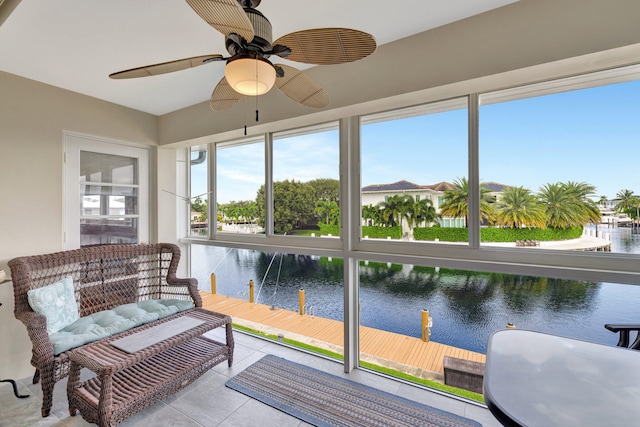 sunroom / solarium featuring ceiling fan and a water view