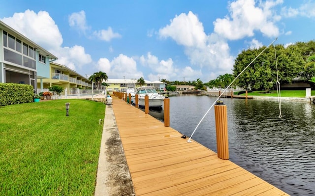 view of dock featuring a water view and a yard