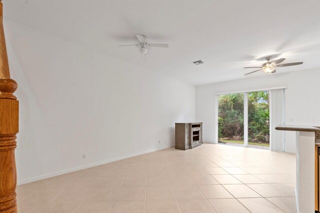 unfurnished living room with a ceiling fan, baseboards, a fireplace, and visible vents