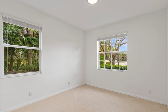 unfurnished room with baseboards and light tile patterned floors