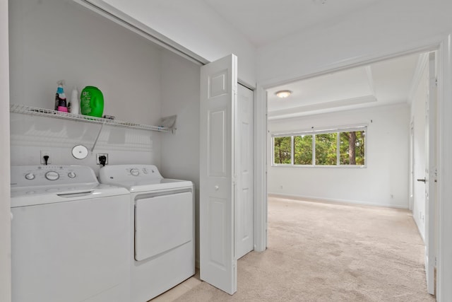 clothes washing area featuring independent washer and dryer, baseboards, laundry area, and light colored carpet