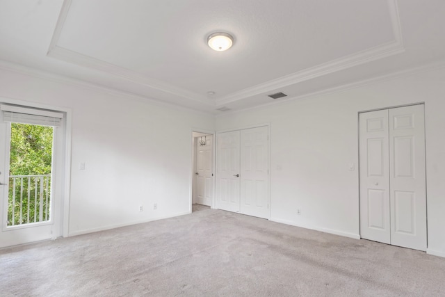 unfurnished bedroom with visible vents, a raised ceiling, and ornamental molding