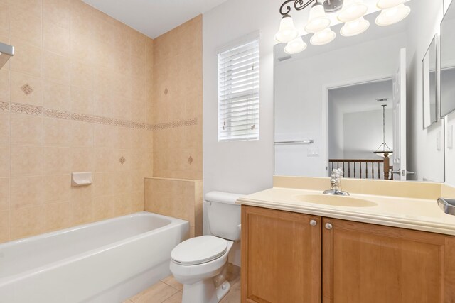 bathroom with toilet,  shower combination, tile patterned flooring, and vanity