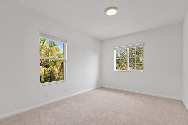 carpeted spare room with plenty of natural light and baseboards