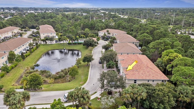 drone / aerial view featuring a wooded view and a water view
