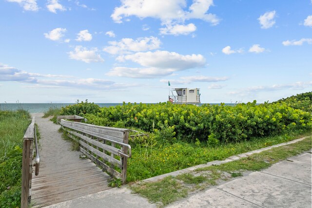 view of property's community featuring a water view and a beach view