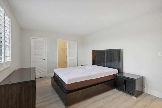 bedroom with light hardwood / wood-style floors and a closet