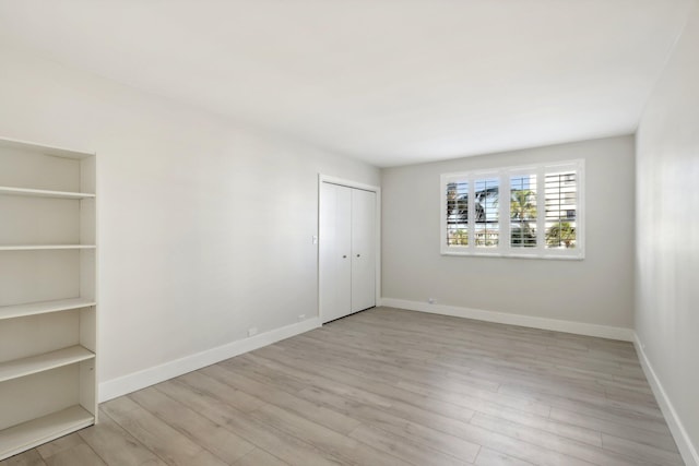 unfurnished bedroom with a closet and light hardwood / wood-style flooring