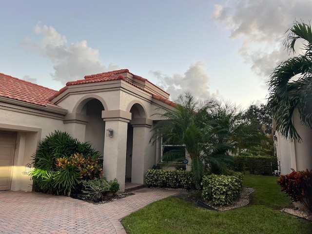 doorway to property with a lawn and a garage