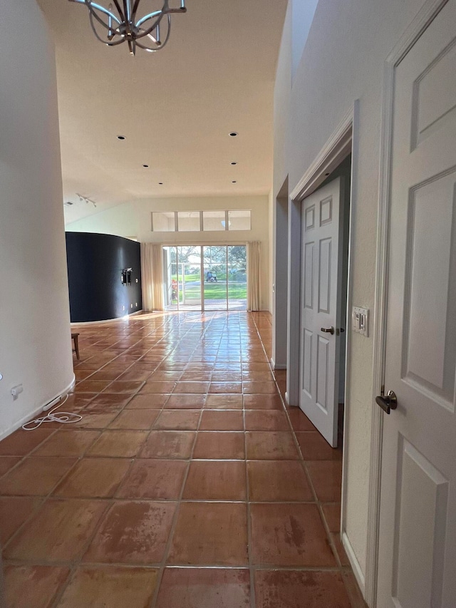 hall with tile patterned floors and a chandelier