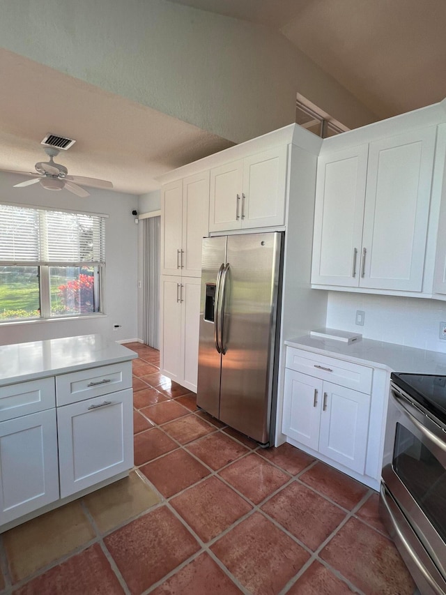 kitchen featuring white cabinetry, ceiling fan, stainless steel appliances, and dark tile patterned flooring