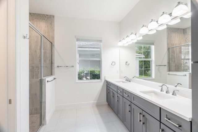 bathroom featuring vanity, a shower with shower door, and tile patterned flooring