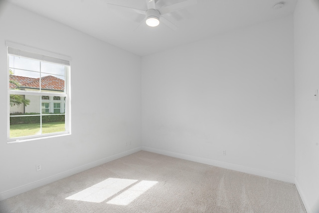 carpeted spare room with plenty of natural light and ceiling fan