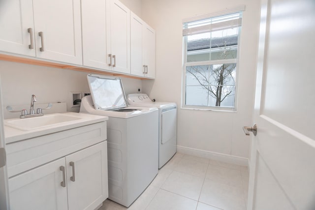 clothes washing area featuring cabinets, separate washer and dryer, light tile patterned floors, and sink