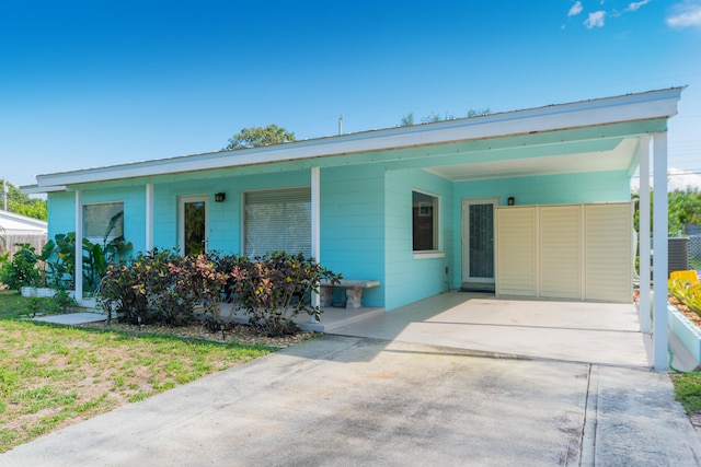 view of front of house featuring central air condition unit and a carport