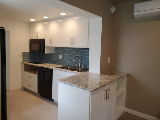 kitchen featuring a wall unit AC, sink, black appliances, white cabinets, and light stone counters