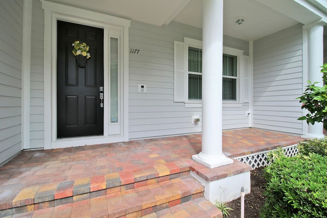 view of exterior entry featuring covered porch