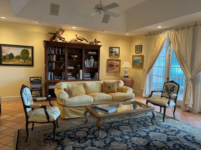 living area with ceiling fan, light tile patterned floors, and a raised ceiling