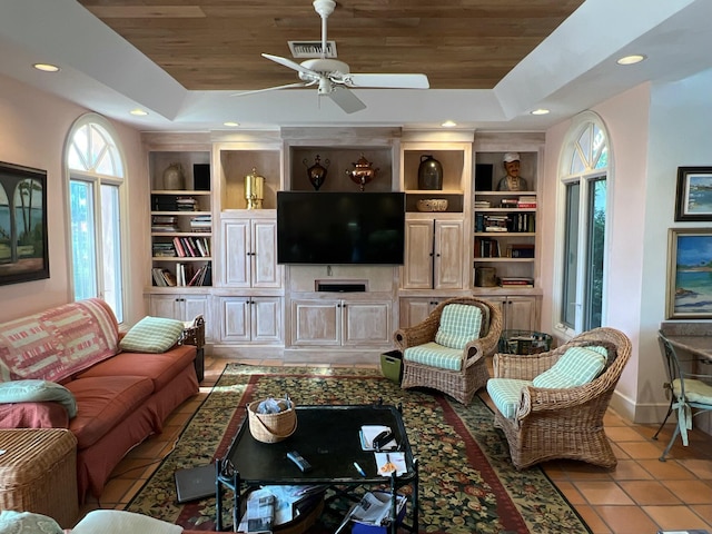 living room featuring wood ceiling, a raised ceiling, and built in shelves