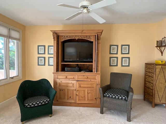 living area with ceiling fan and light colored carpet