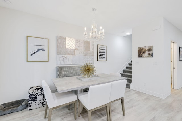 dining space featuring a chandelier and light wood-type flooring