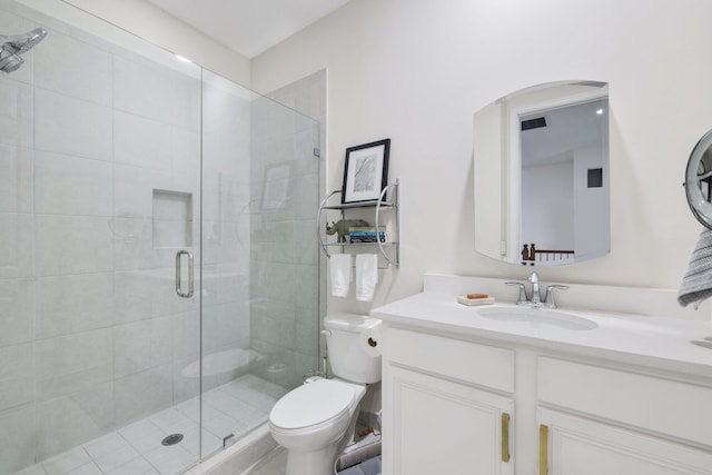 bathroom with a shower with door, vanity, and toilet