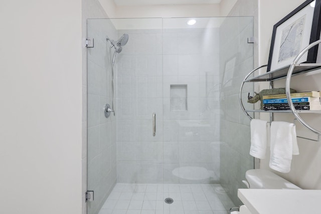 bathroom featuring vanity, toilet, and a shower with door