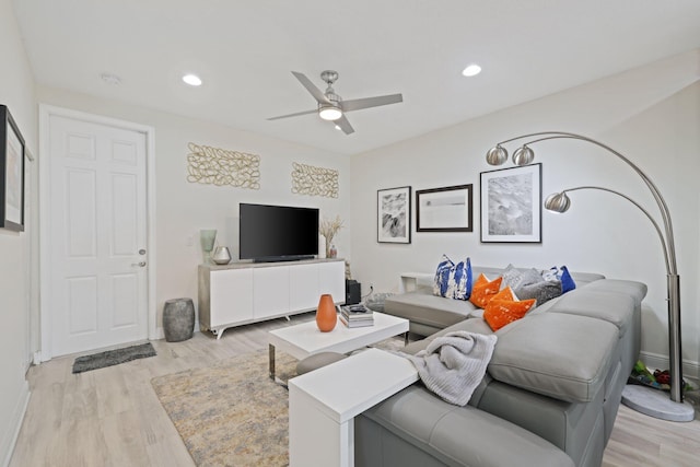 living room featuring light hardwood / wood-style flooring and ceiling fan