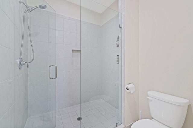 bathroom with a shower with door and toilet