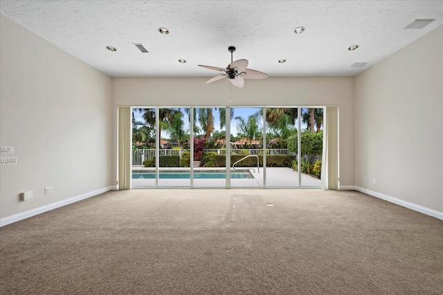 carpeted empty room with ceiling fan, visible vents, plenty of natural light, and baseboards