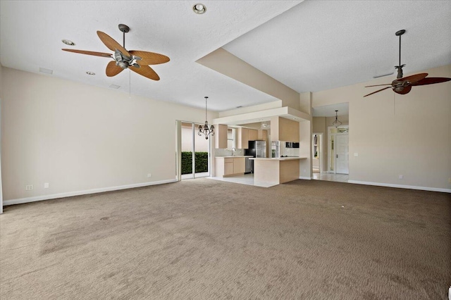 unfurnished living room featuring light carpet, a textured ceiling, sink, and ceiling fan with notable chandelier