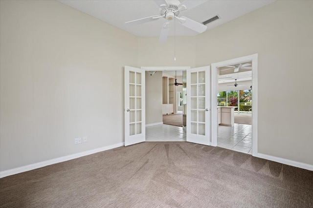 unfurnished room with french doors, ceiling fan, a towering ceiling, and light colored carpet