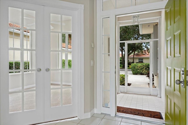 entryway featuring baseboards, tile patterned floors, and french doors