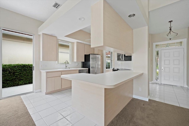 kitchen featuring visible vents, light brown cabinetry, appliances with stainless steel finishes, a sink, and light tile patterned flooring
