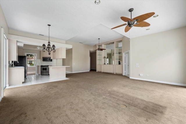 unfurnished living room featuring baseboards, visible vents, ceiling fan with notable chandelier, and light colored carpet