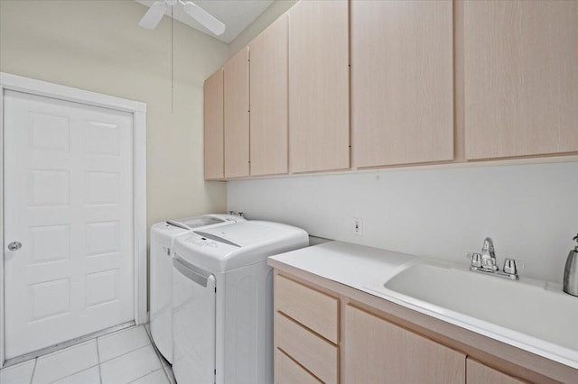 washroom with a sink, light tile patterned flooring, a ceiling fan, cabinet space, and independent washer and dryer