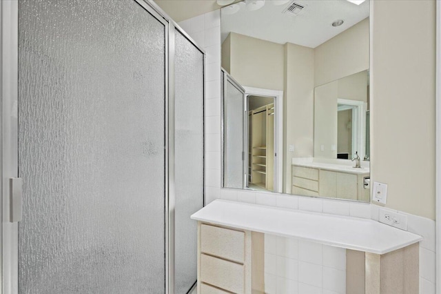 bathroom featuring visible vents, a shower stall, and vanity