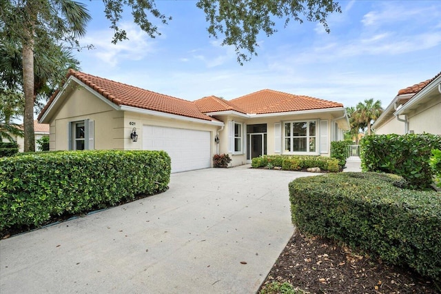 view of front of house featuring a garage, stucco siding, a tile roof, and concrete driveway