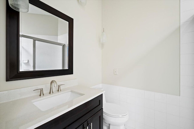bathroom with vanity, a shower stall, and toilet