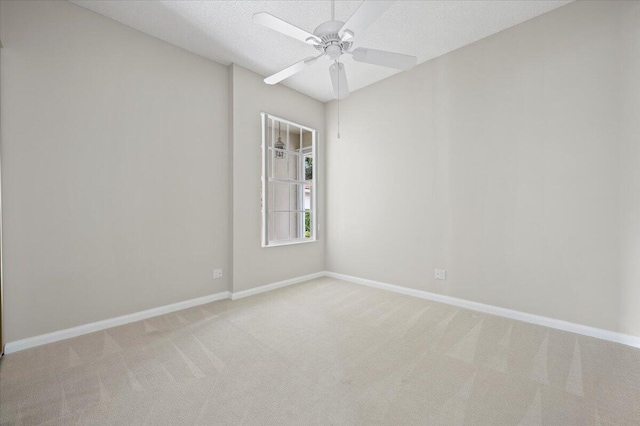 empty room with light carpet, a textured ceiling, and ceiling fan