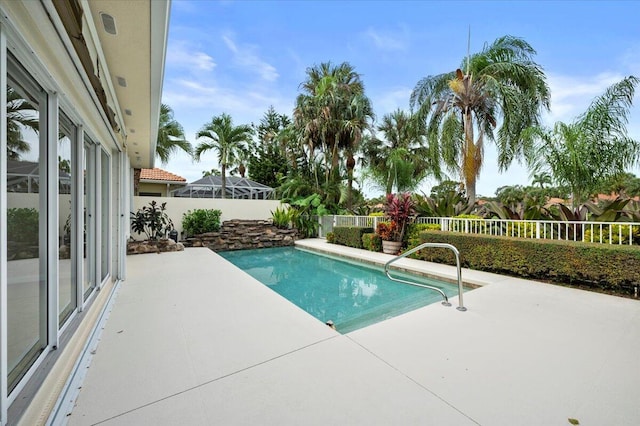 view of swimming pool with a patio area and a lanai