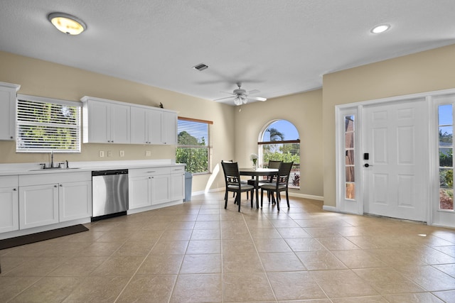 kitchen with ceiling fan, sink, light tile patterned floors, dishwasher, and white cabinetry