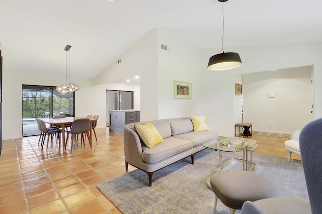 tiled living room featuring high vaulted ceiling and an inviting chandelier