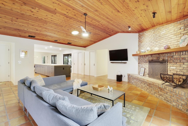 living room featuring wood ceiling, vaulted ceiling, ceiling fan, a fireplace, and light tile patterned flooring